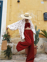 Pleated Wide Pants in red against a yellow wall