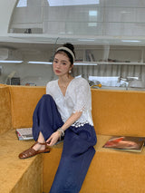 Embroidered V-Neck Top in white on a mustard sofa