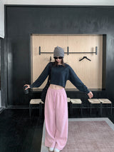 Woman with arms out in pink low rise wide sweatpants and a cropped sweatshirt