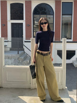 Navy fitted crop knit tee worn with wide trousers in front of a brick townhouse