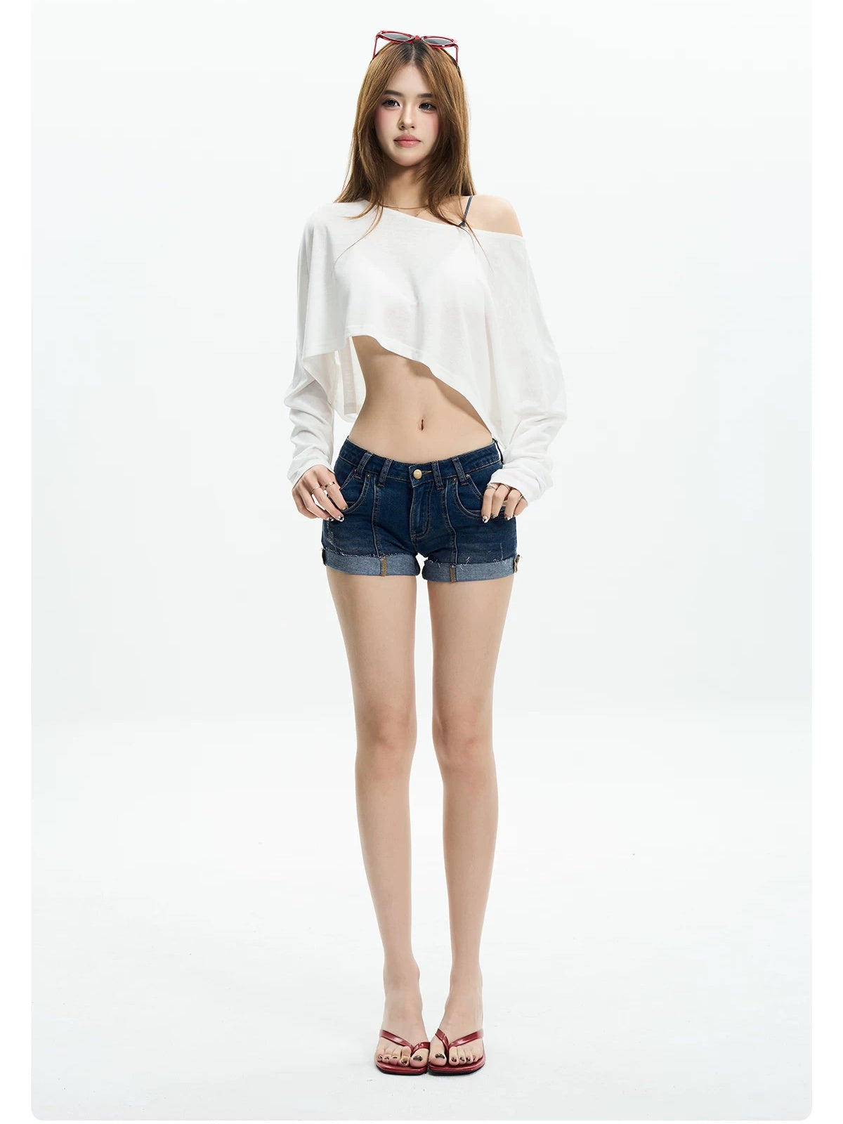 Woman in a white off shoulder crop tee and low-rise denim shorts